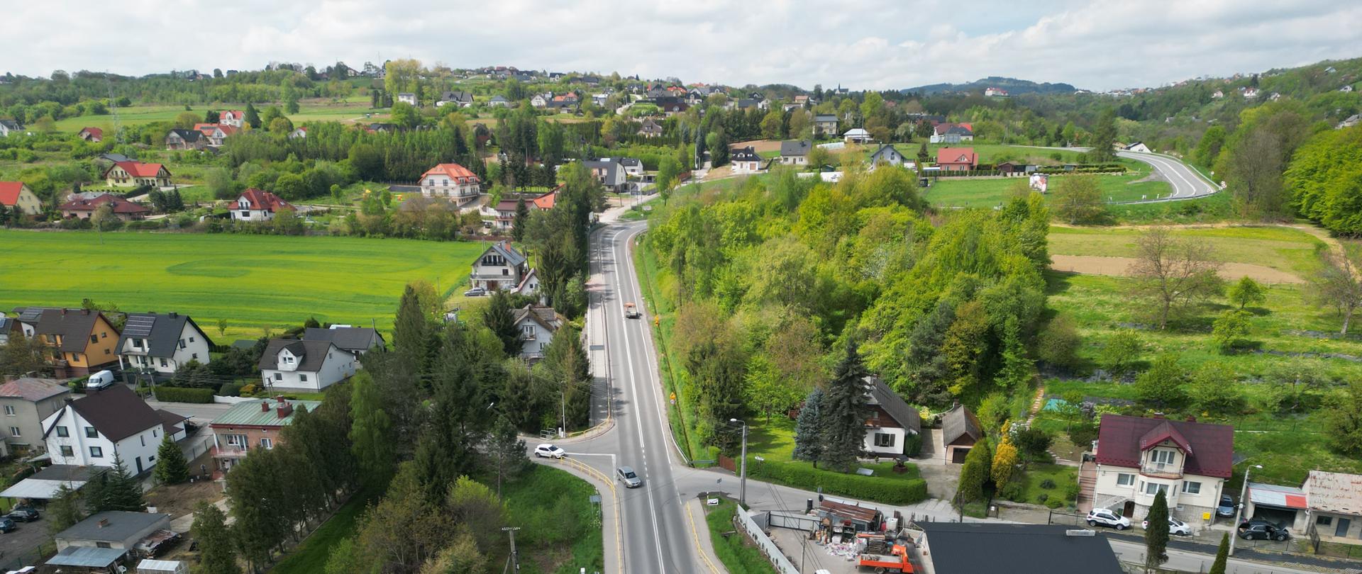 DK28, wzdłuż trasy zabudowania, w tle Beskidy