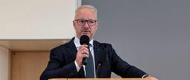 Na zdjęciu widać wojewodę trzymającego mikrofon w dłoni