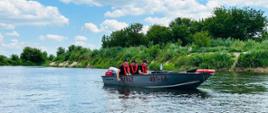 Trzech strażaków płynących na łodzi podczas poszukiwań osoby zaginionej na rzece Narew