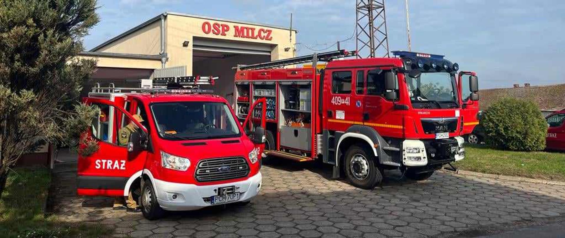 Zdjęcie przedstawia strażaków sprawdzających sprzęt strażacki podczas jesiennych przeglądów technicznych oraz samochody gaśnicze.
W tle budynek remizy OSP.
