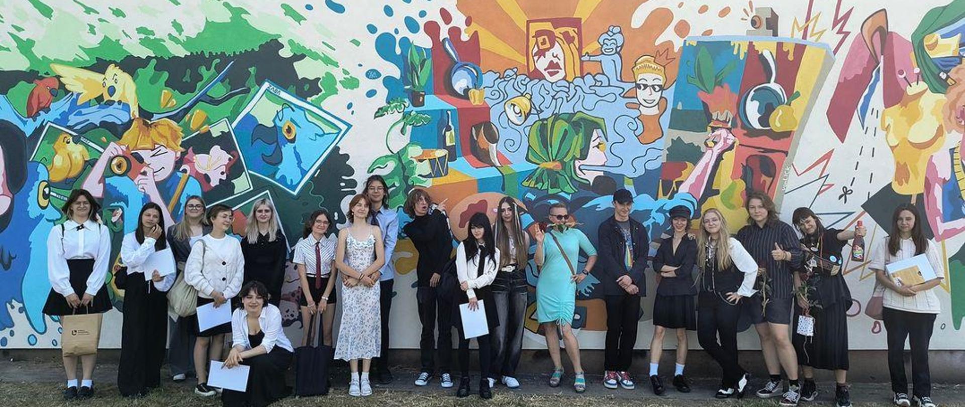 Na zdjęciu grupa uczniów wraz z opiekunem , którzy zrealizowali projekt muralu.