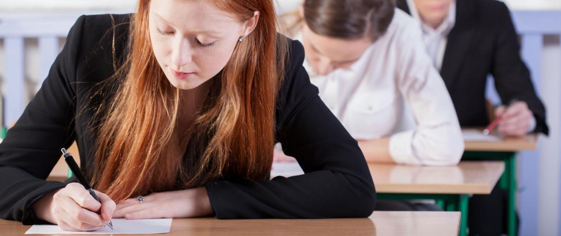 Zdjęcie przedstawia osoby piszące egzamin