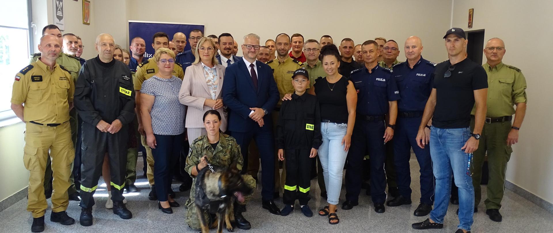 Wojewoda Warmińsko - Mazurski, Komendanci Wojewódzcy Państwowej Straży Pożarnej, Policji, Straży Granicznej oraz funkcjonariusze służb powiatu bartoszyckiego wraz z chłopcem, który zaangażował się w działania poszukiwawcze zaginionej kobiety