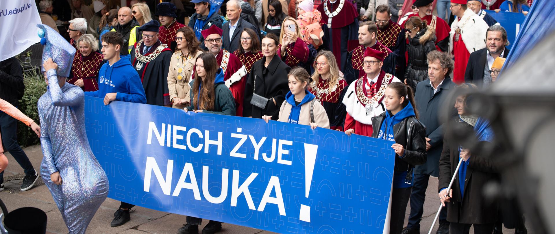 kolorowa parad , ludzie idą ulica Długa w Gdańsku i niosą baner z napisem Niech Żyje nauka