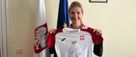 Chargé d’affaires a.i. Monika Krzepkowska trzymająca koszulkę z autografami