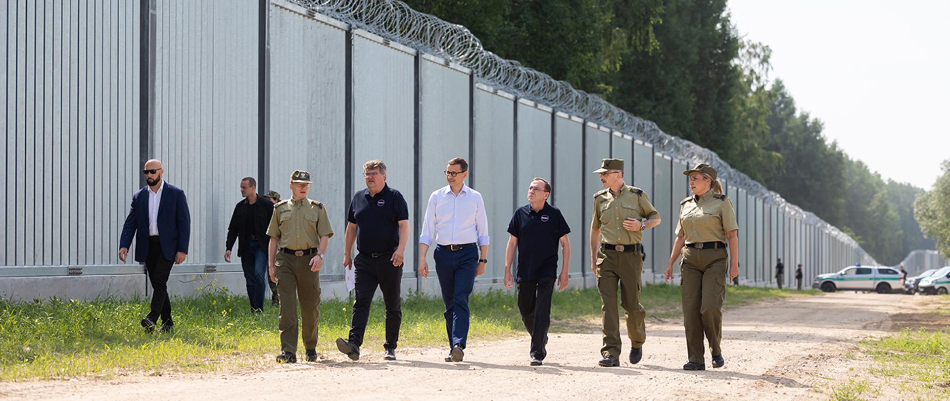 Premier Mateusz Morawiecki, minister Mariusza Kamiński, wiceminister Maciej Wąsik oraz kierownictwo Straży Granicznej oglądają zaporę na polsko- białoruskiej granicy