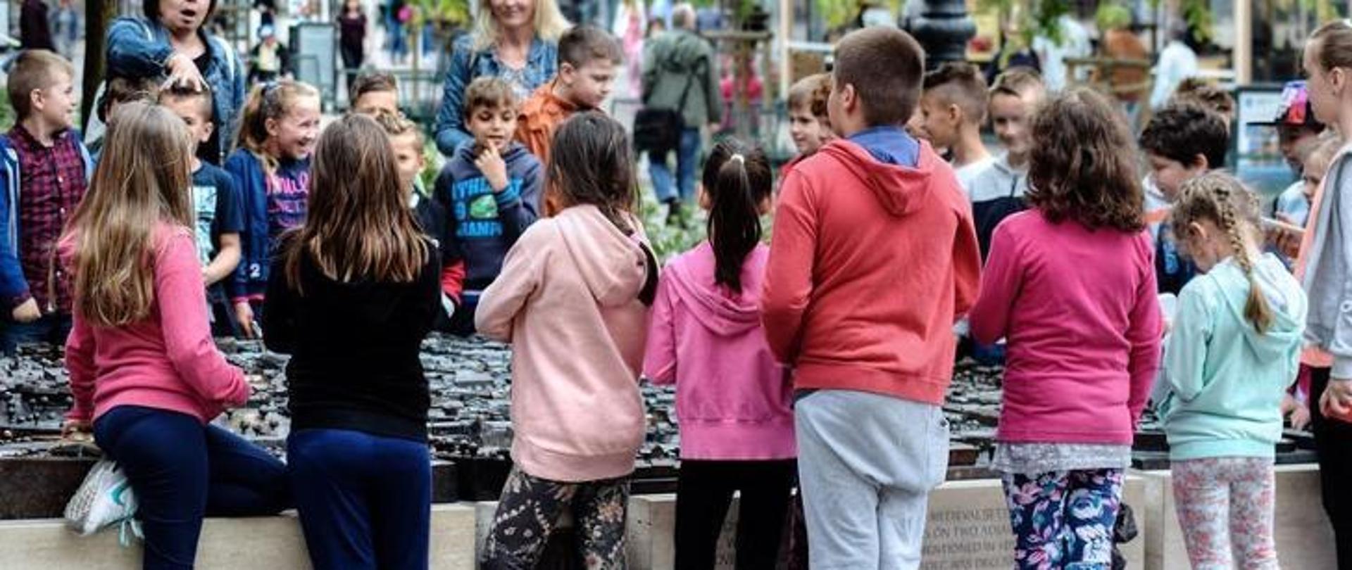 Grupa dzieci stoi przy makiecie miasta