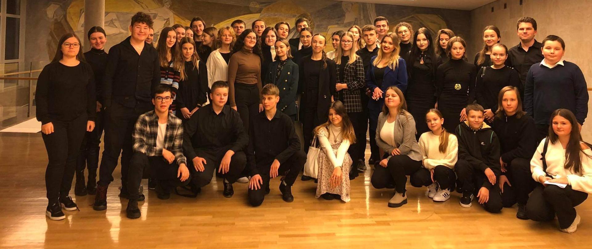zdjęcie grupowe przedstawiające uczniów szkoły muzycznej w Mielcu w holu Filharmonii Podkarpackiej im. Artura Malawskiego w Rzeszowie.