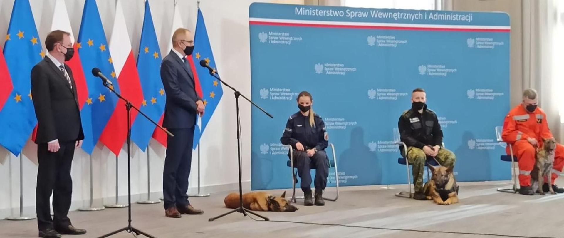 Na zdjęciu Minister Spraw Wewnętrznych oraz przedstawiciele trzech służ ratowniczych z psami.