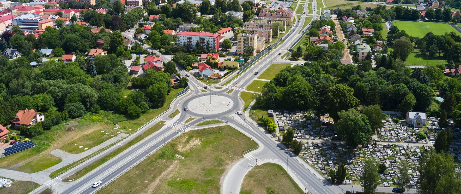 Obwodnica Łańcuta w ciągu DK94 - zdjęcie z lotu ptaka, po lewej stronie widać drogę i rondo, jeżdżą samochody, po prawej stronie widać cmentarz 