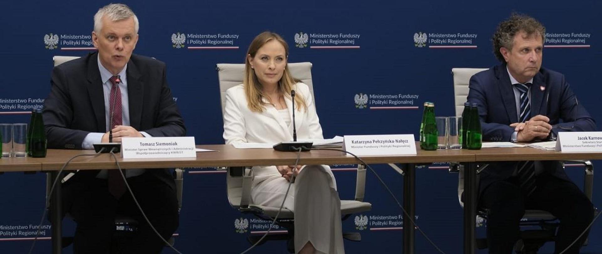Minister funduszy i polityki regionalnej Katarzyna Pełczyńska-Nałęcz siedzi przy stole, po jej prawej stronie siedzi minister spraw wewnętrznych i administracji Tomasz Siemoniak, zaś po lewej jest wiceminister funduszy i polityki regionalnej Jacek Karnowski