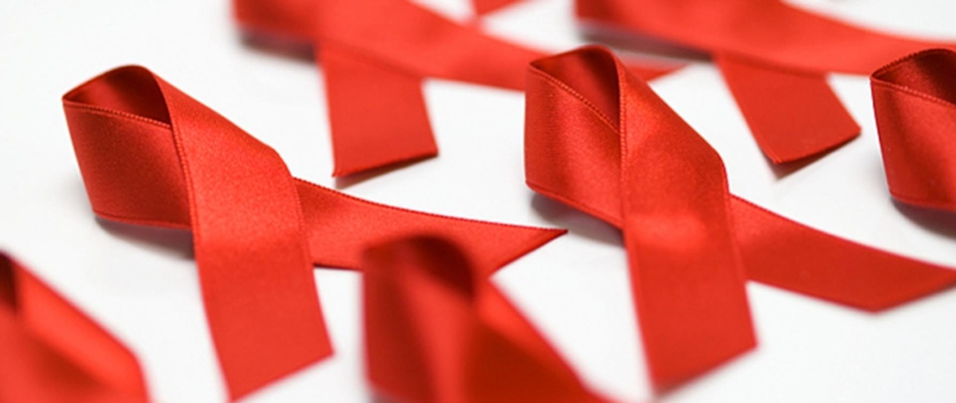 Zdjęcie, na którym widoczne są czerwone wstążki charakterystyczne dla działań akcyjnych dot. profilaktyki HIV/AIDS.