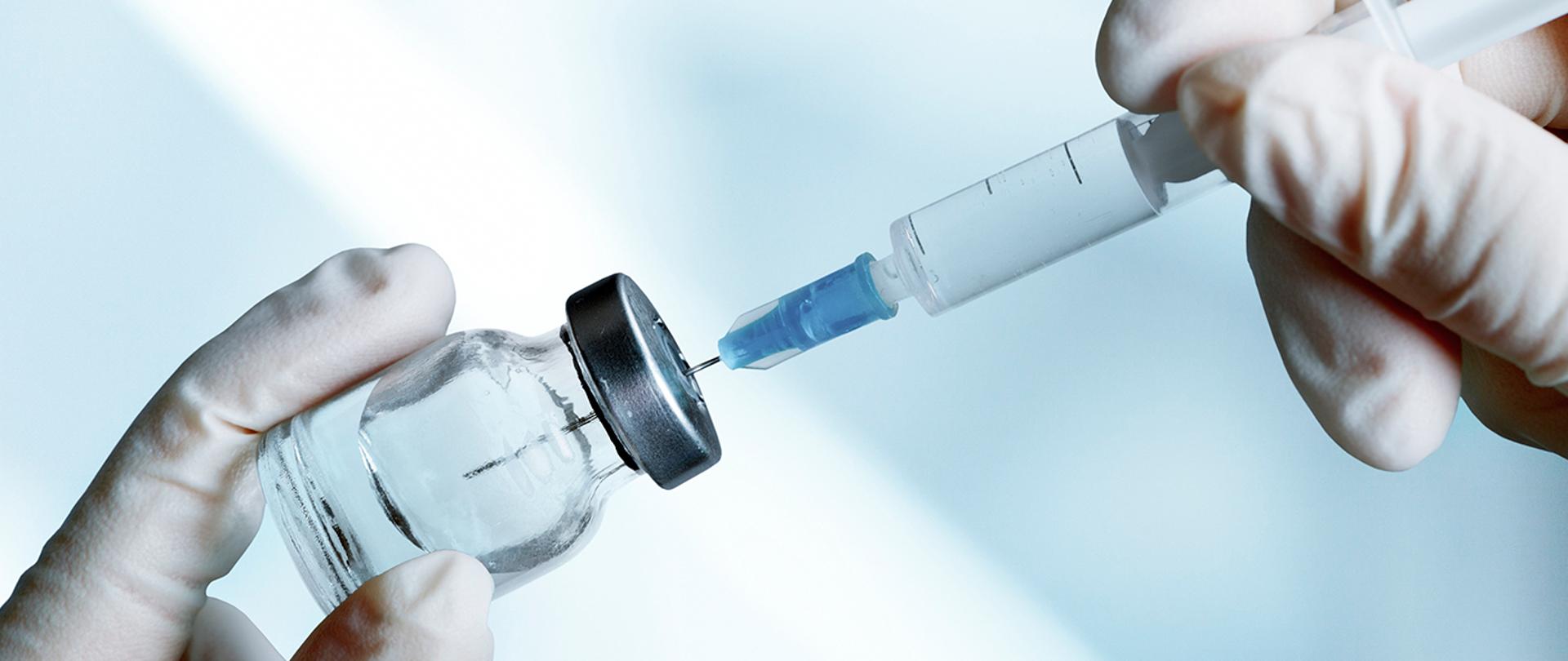 Zdjęcie, na którym widnieje fiolka ze szczepionką oraz strzykawka.