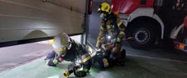 strażacy w trakcie ćwiczenia egzaminacyjnego z zakresu gaszenia pożarów wewnętrznych na garażu jednostki