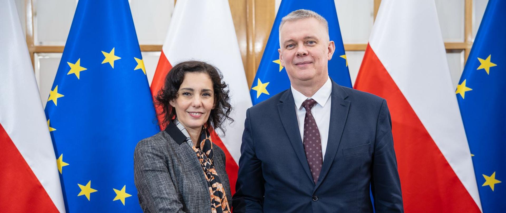 Minister Tomasz Siemoniak and Commissioner Hadja Lahbib stand against the background of Polish and European flags.