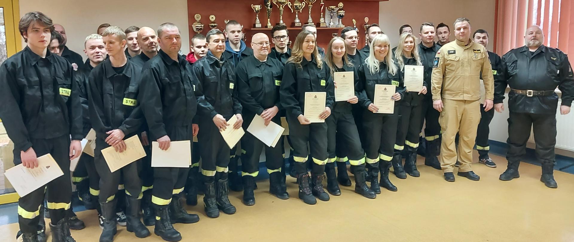 Strażacy ratownicy Ochotniczych Straży Pożarnych z wręczonymi zaświadczeniami o ukończonym kursie podstawowym