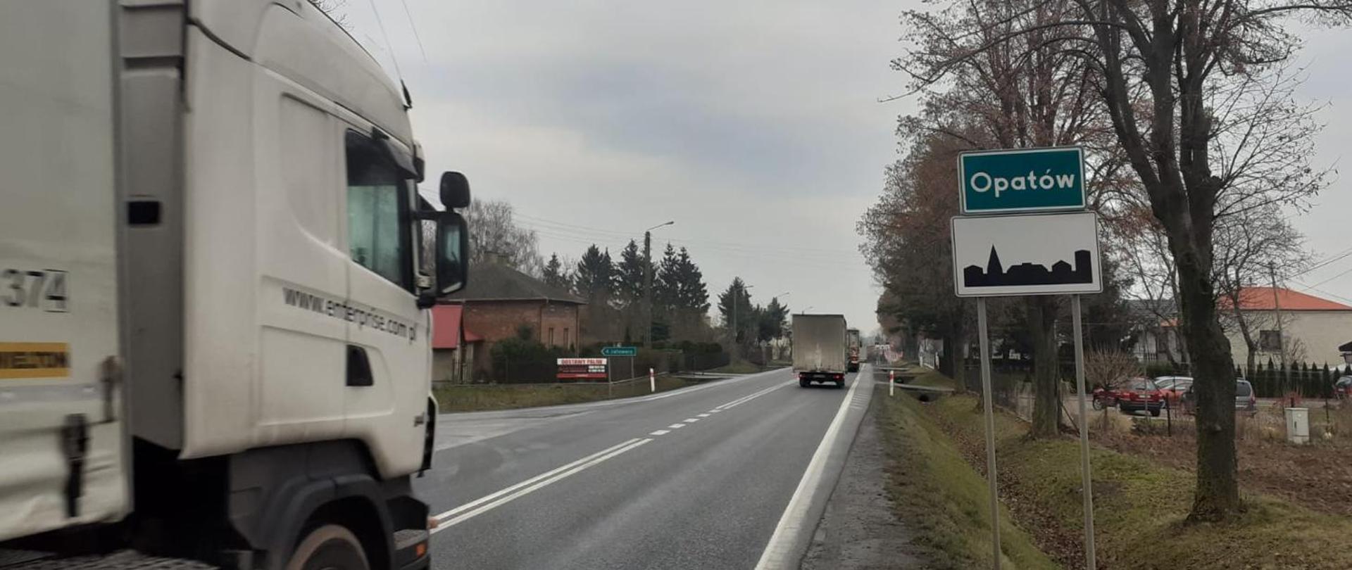 Wjazd do Opatowa DK74 od strony Kielc (jednojezdniowa droga, ciężarówka, tablica z nazwą miasta i oznakowanie terenu zabudowanego) 