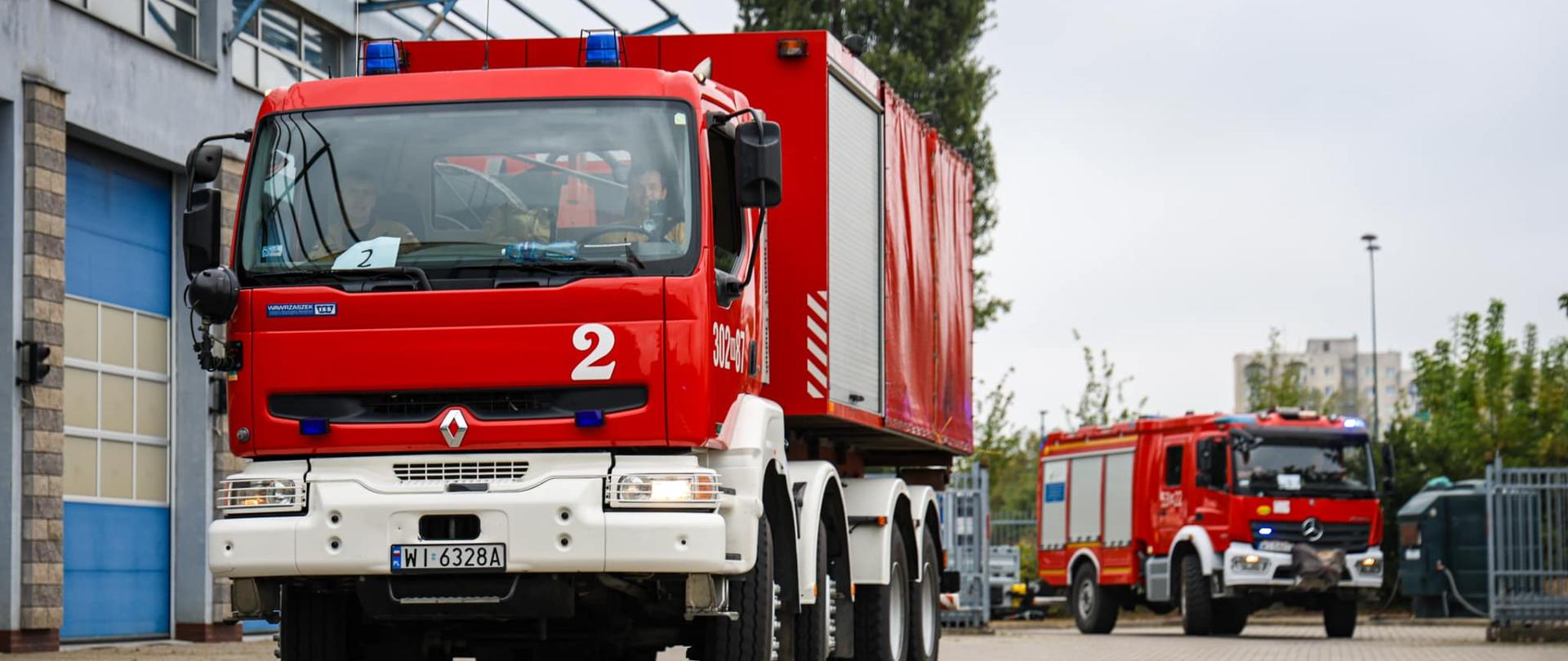 wozy strażackie stoją przed remizą