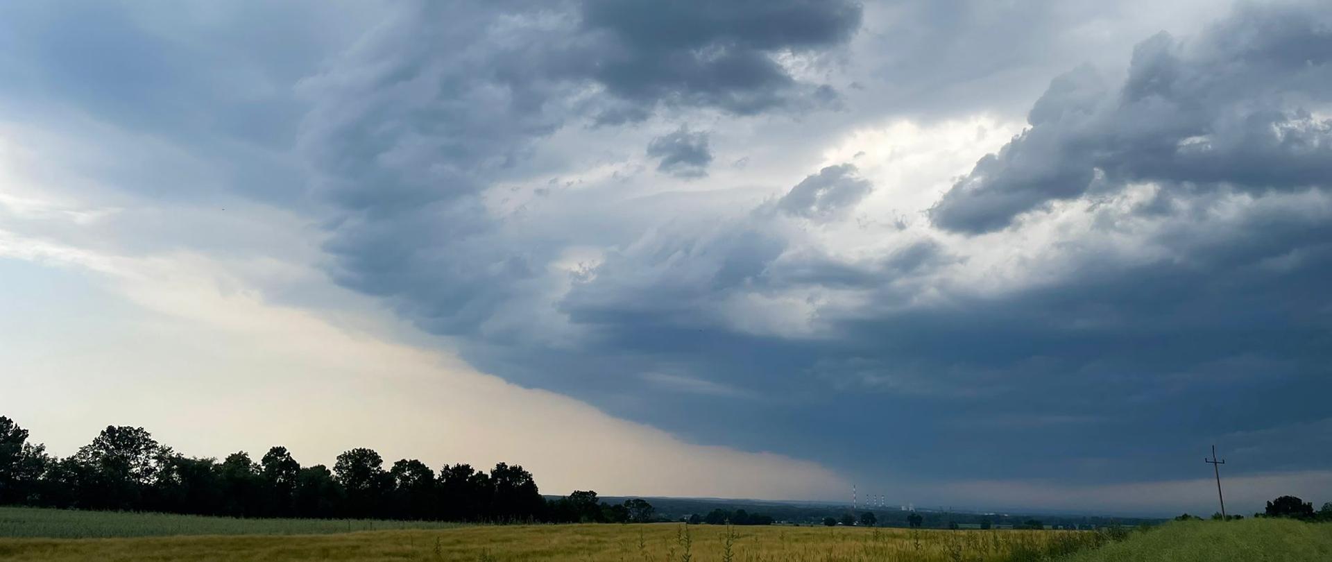 Front burzowy - ciemne chmury nad terenem rolniczym