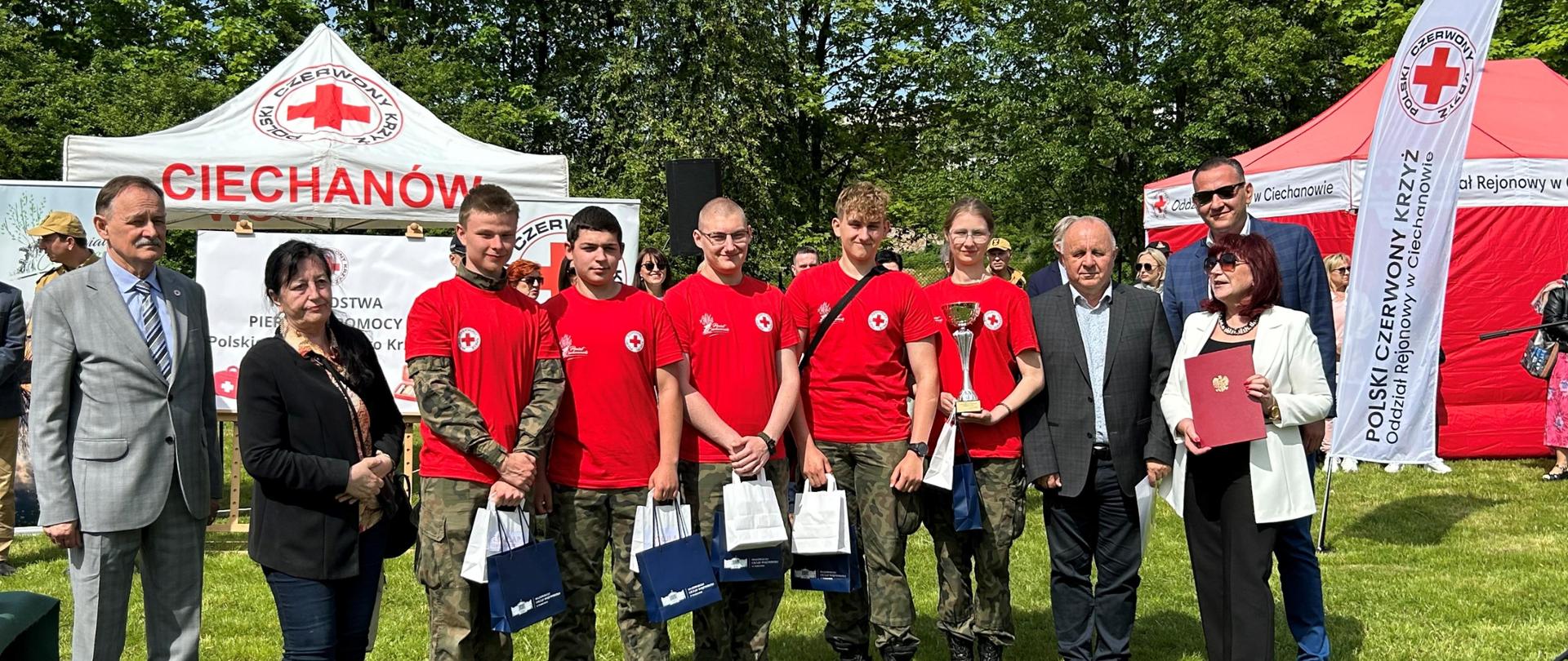 Na zdjęciu grupa ludzi. W dłoniach trzymają nagrody