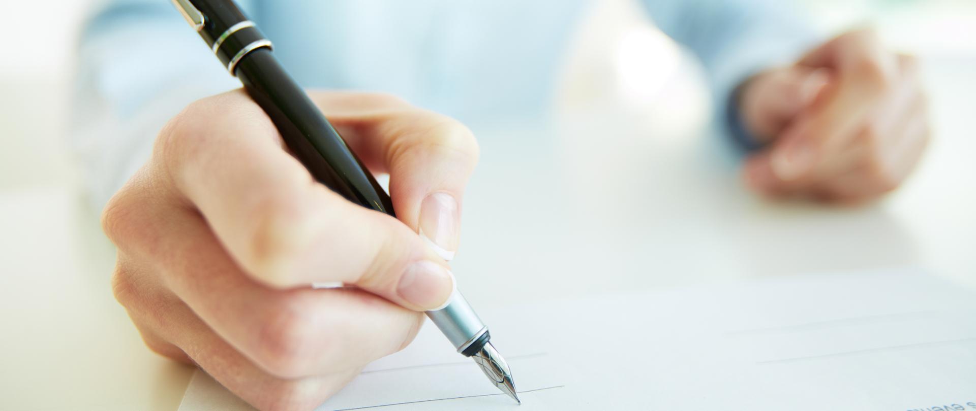 Close-up image of a business woman being to put her signature