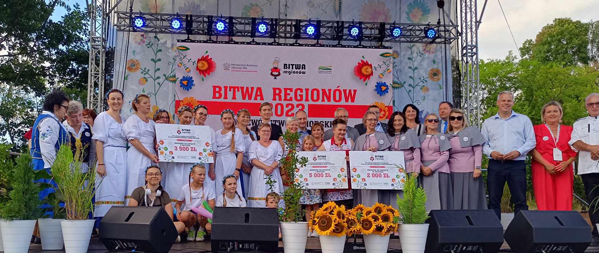 Laureaci i laureatki II etapu konkursu kulinarnego Bitwa Regionów w strojach organizacyjnych z dyplomami na scenie