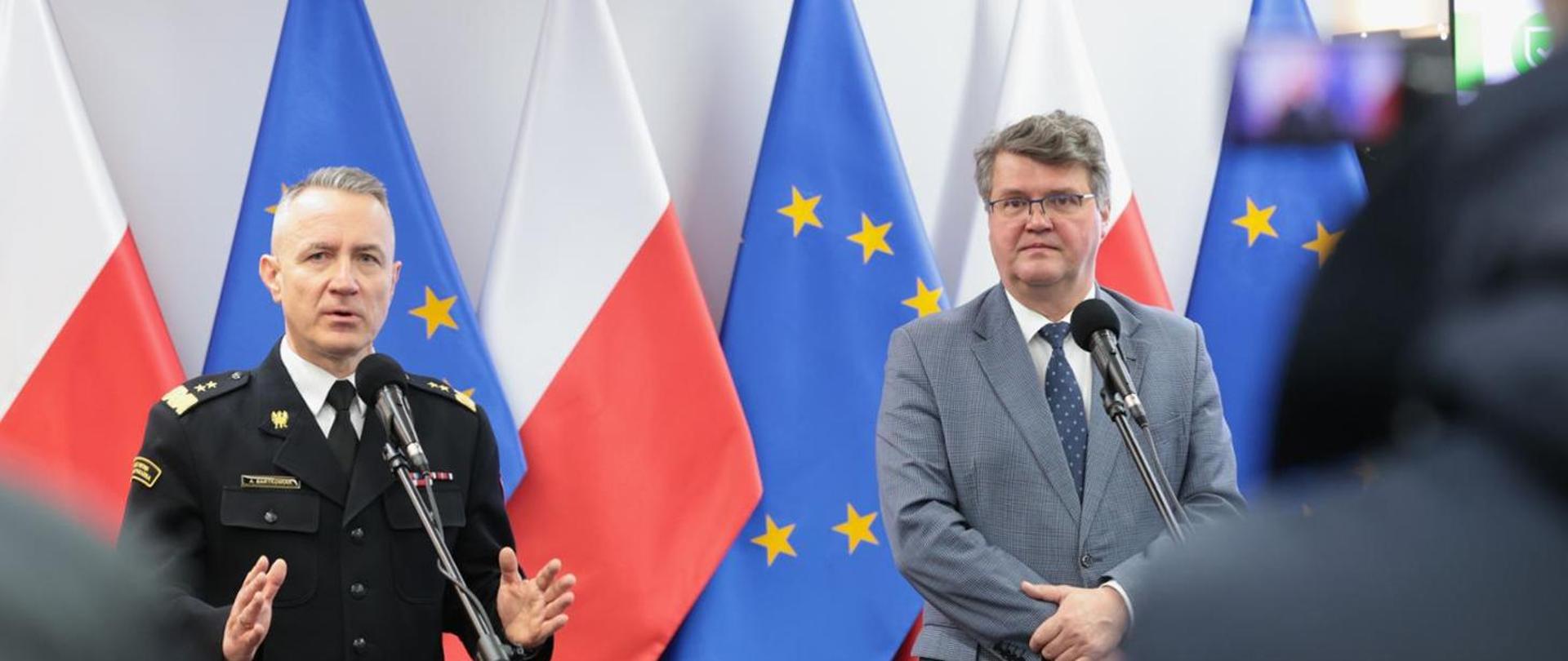 wiceminister Maciej Wąsik na konferencji z gen. brygadierem Andrzejem Bartkowiakiem, w tle flagi Polski oraz Unii Europejskiej