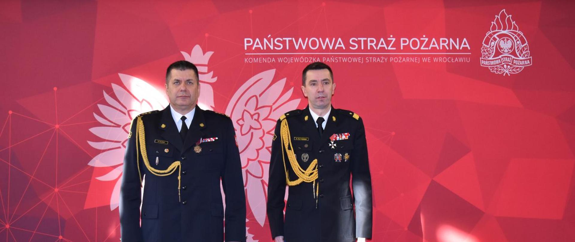 Komendant Główny i Dolnośląski Komendant Wojewódzki ustawieni na czerwonym tle z logiem Państwowej Straży Pożarnej