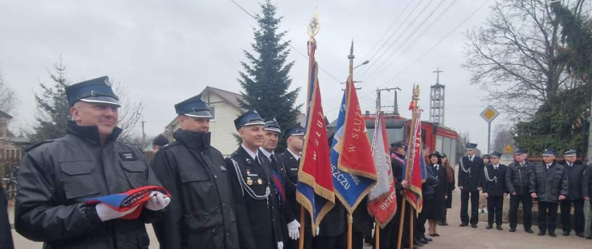 Zdjęcie przedstawia uroczystość przekazania nowego samochodu ratowniczego dla OSP Jasienica. Na zdjęciu widoczni są oficjalni gości oraz strażacy OSP. Uroczystość przebiega na placu przed jednostką.