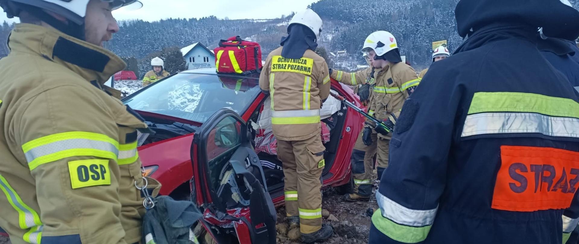 Strażacy prowadzą działania przy samochodzie 