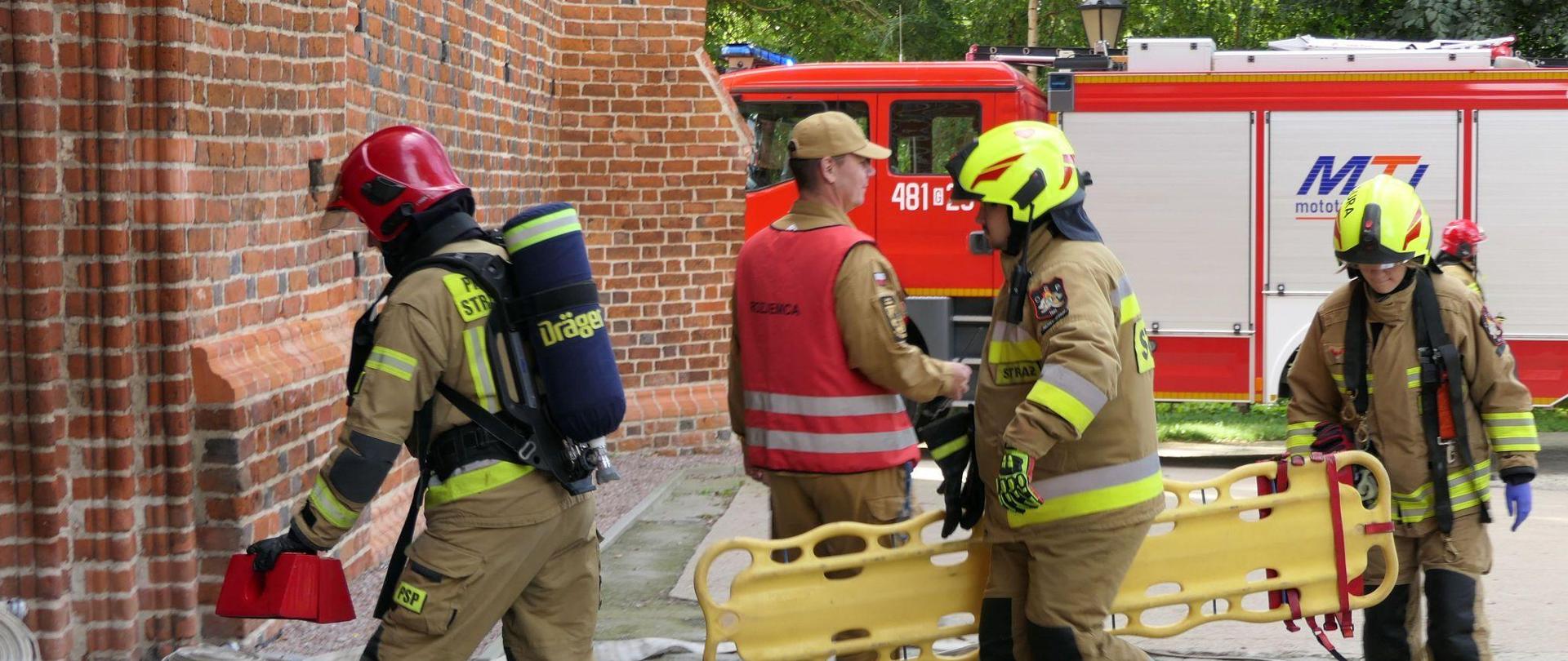 Zdjęcie przedstawia ratowników przygotowujących się do wejście do kościoła