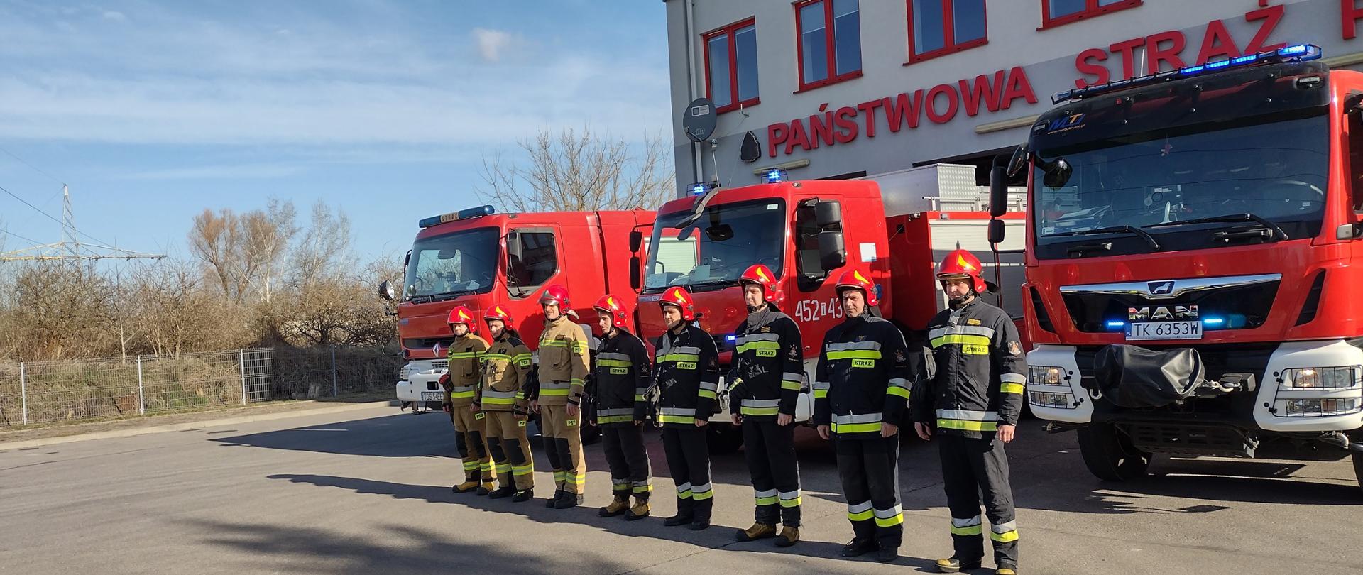 Ostrowieccy strażacy przed garażem na tle samochodów gaśniczych oddają hołd ofiarom katastrofy Smoleńskiej 