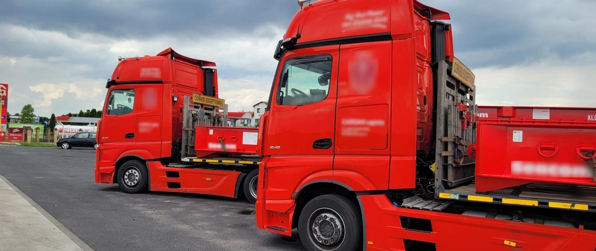 Dwa czerwone zespoły pojazdów ciężarowych stojące na parkingu stacji Orlen do kontroli.