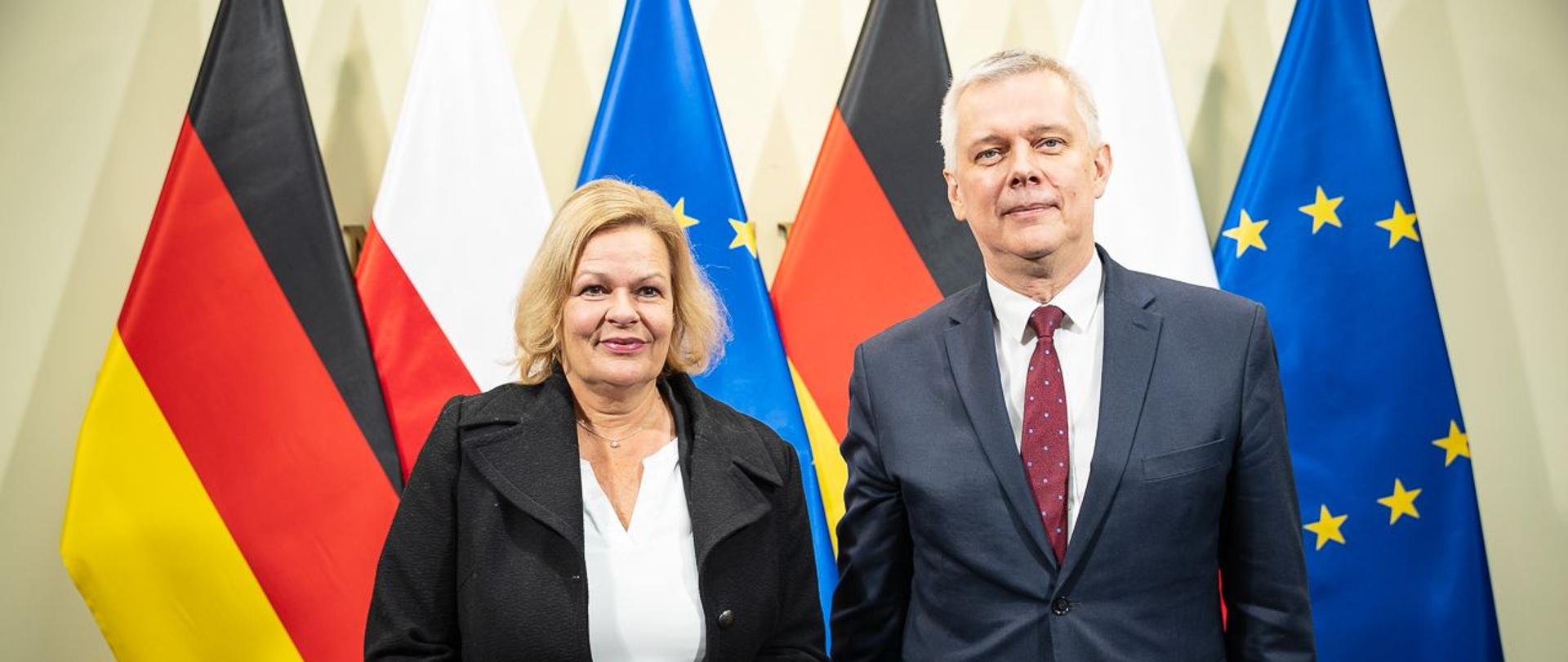 Minister Tomasz Siemoniak and Federal Minister of the Interior and Fatherland of Germany Nancy Faeser standing in front of the flags of Poland, Germany and the EU.