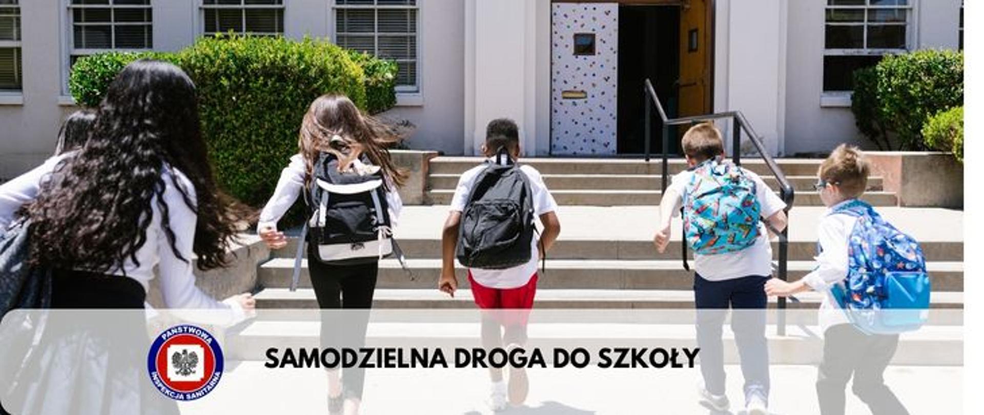 Zdjęcie przedstawia piątkę dzieci idących w kierunku wejścia szkoły na dole logo Państwowej Inspekcji Sanitarnej i napis SAMODZIELNA DROGA DO SZKOŁY