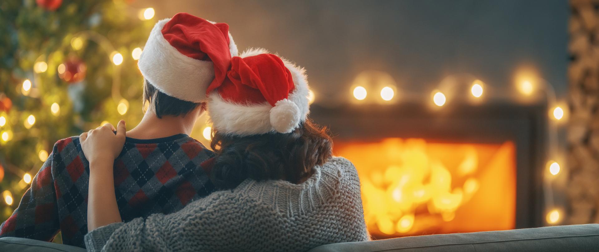 Loving couple relaxing near fireplace Christmas tree at home.