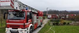 zastępy straży pożarnej przy pożarze budynku mieszkalnego w Wąchocku