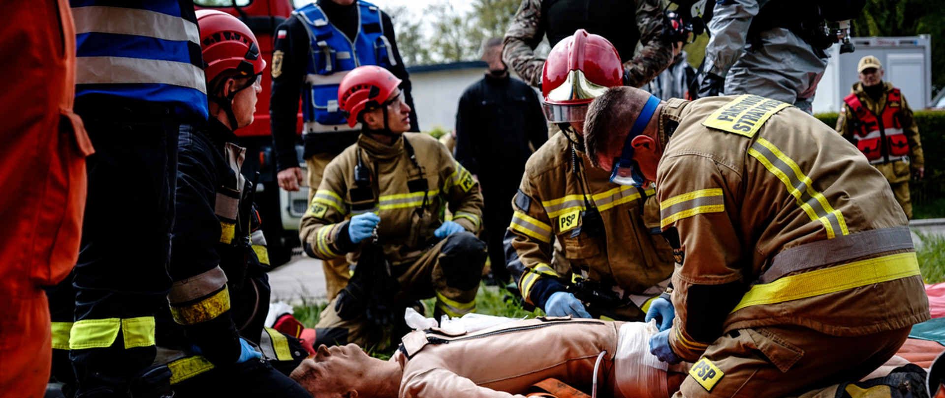 Zdjęcie przedstawia strażaków podczas ćwiczeń. Stanowisko udzielania pierwszej pomocy poszkodowanym