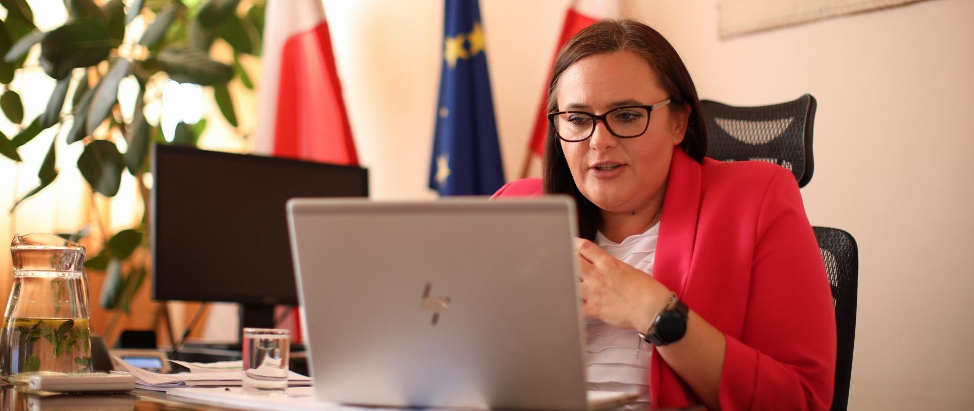 Minister Małgorzata Jarosińska-Jedynak podczas Konwentu Marszałków Województw RP, siedzi przed monitorem komputera.