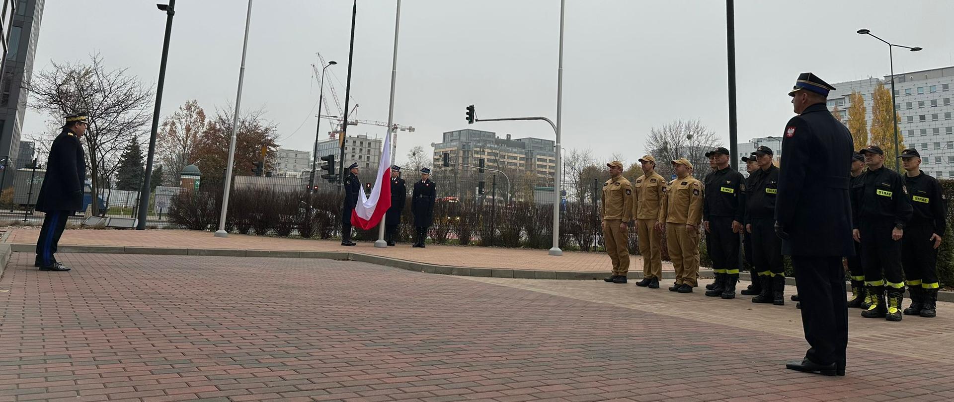 Pododdział strażaków przy maszcie flagowym 