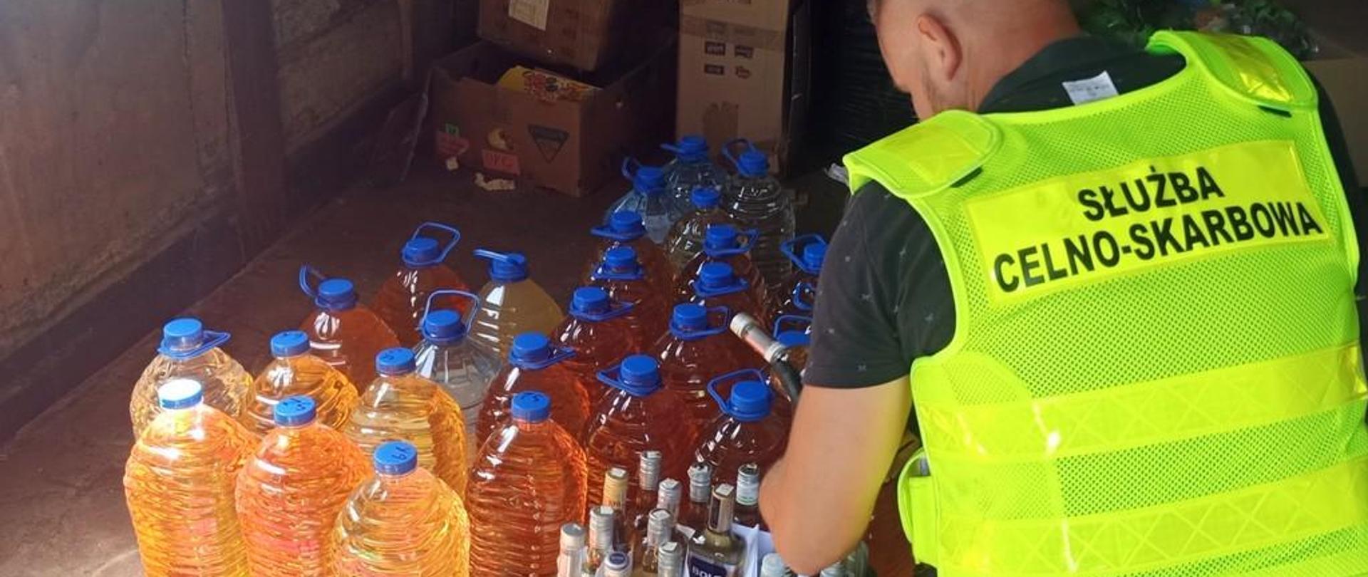 Funkcjonariusz KAS przy zabezpieczonym alkoholu