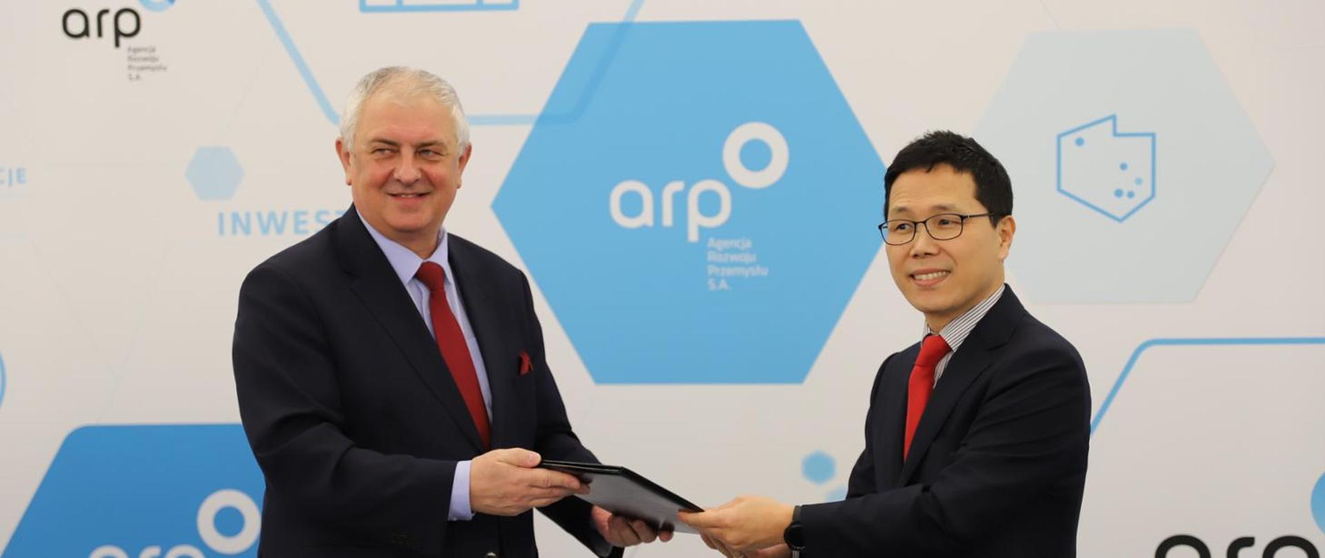 Deputy Minister Grzegorz Piechowiak and the CEO of the South Korean company Enchem Poland holding a document confirming support for the investment 