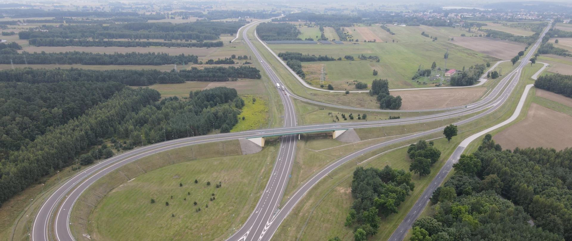 Węzeł drogowy Kock Północ widziany z lotu ptaka. Pogoda wiosenna, w tle widoczne zabudowania.