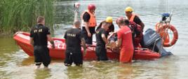 Strażacy przedstawiają techniki ratownicze osób poszkodowanych nad wodą przy użyciu łodzi ratowniczej