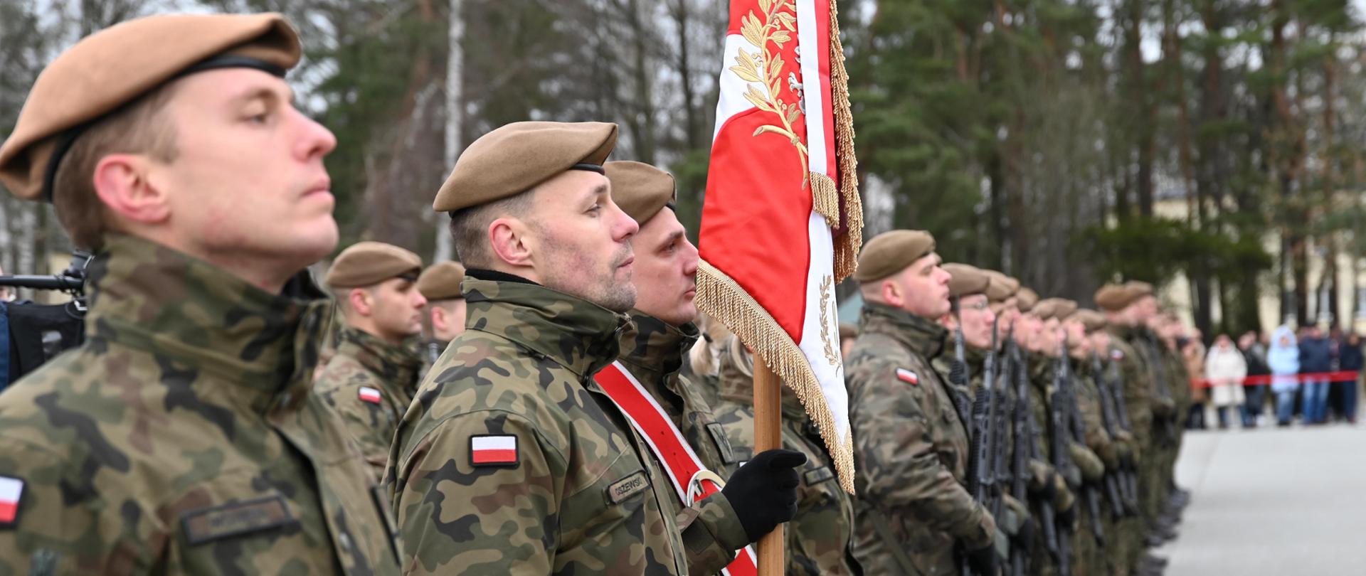 Żołnierze trzymający sztandar wojskowy 