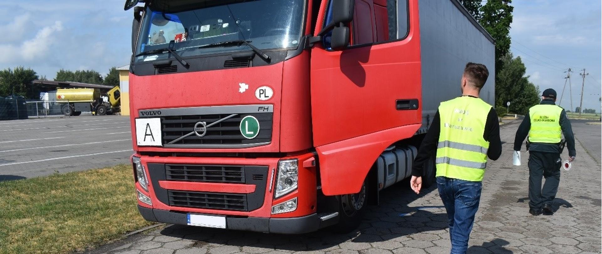 Inspektor Wojewódzkiego Inspektoratu Ochrony Środowiska w Warszawie kontroluje samochód ciężarowy.