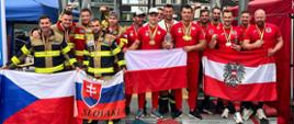 Zawodnicy zawodów i Reprezentacja Polski na zawodach 18 Firefighter Combat Challenge Berlin. Zawodnicy trzymają przed sobą flagi panstowe.