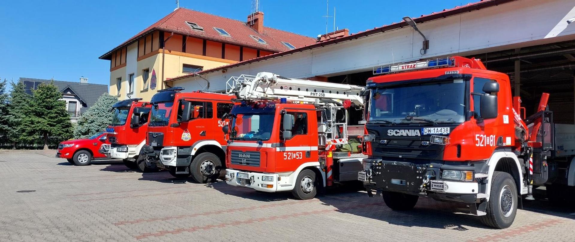 Pojazdy pożarnicze przed garażem JRG