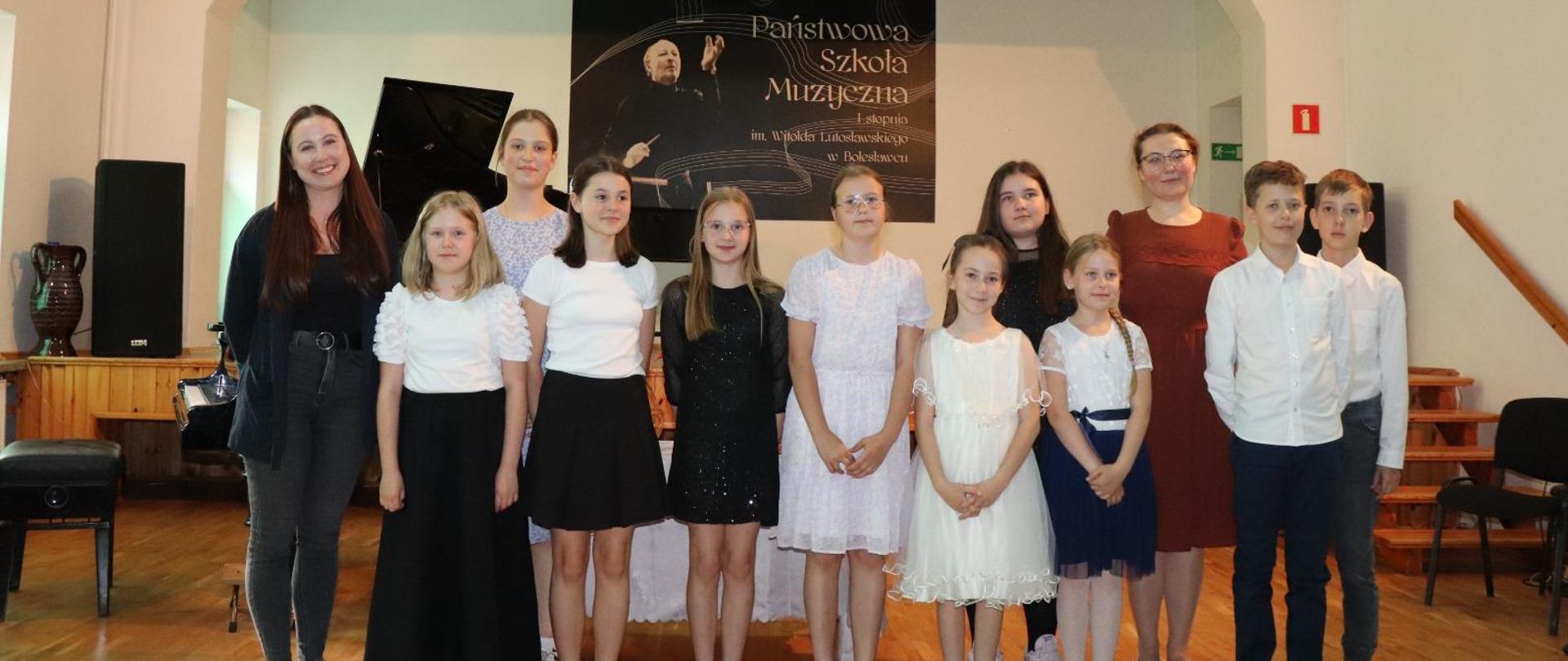 Zdjęcie przedstawiające wykonawców popisu klasy skrzypiec Agaty Klich i fortepianu Lillii Tarasenko, który odbył się 21 maja 2024 r. w auli szkoły.