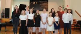 Zdjęcie przedstawiające wykonawców popisu klasy skrzypiec Agaty Klich i fortepianu Lillii Tarasenko, który odbył się 21 maja 2024 r. w auli szkoły.